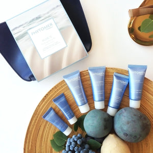 Purifying Starter Kit | Phytomer featuring blue skincare tubes arranged on a wooden tray with natural elements and a box in the background, highlighting a calm wellness aesthetic.