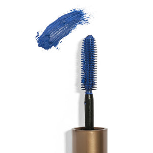 Close-up of a blue mascara brush covered in vibrant pigment next to a swatch of blue mascara, showcasing the Drama & Shade Mini Mascara Set | Chella.