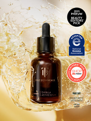 Chebula Active Serum | True Botanicals bottle with dropper, surrounded by golden liquid splash, featuring awards and certifications for skincare excellence and ingredient integrity.
