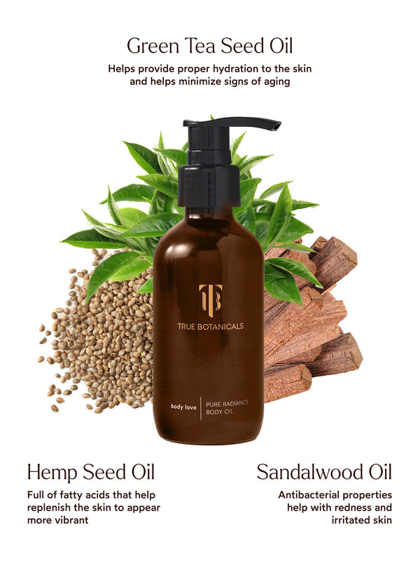 Bottle of Pure Radiance Body Oil | True Botanicals surrounded by green tea leaves, hemp seeds, and sandalwood pieces, highlighting key hydrating and soothing ingredients for skincare.