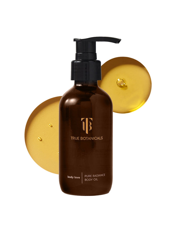 Brown pump bottle of Pure Radiance Body Oil | True Botanicals with golden oil droplets on a white background, highlighting skincare and body care wellness.