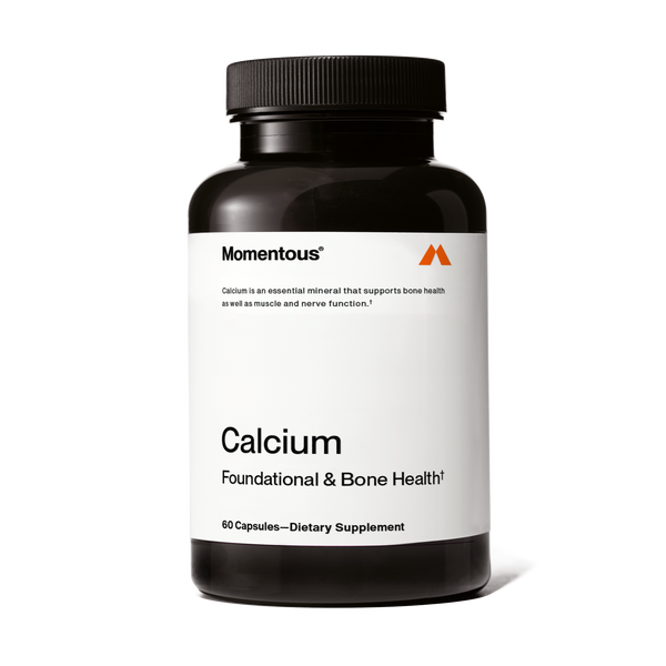 A black bottle of Calcium dietary supplement capsules with a white label highlighting its support for bone, muscle, and nerve health.