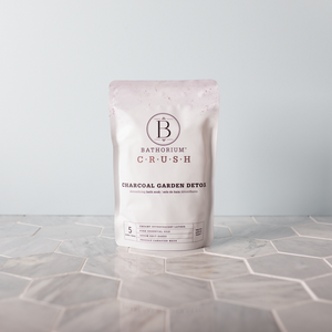 Packaging of Charcoal Garden Detox Crush | Bathorium bath soak, standing on a hexagonal tile surface with soft natural lighting, showcasing skincare and body care wellness product.