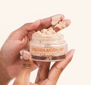 Close-up of hands holding an open jar of Golden Moon Dip® Illumination Mousse with Retinol + Wrinkle-Targeting Peptides | Farmhouse Fresh, showing creamy, iridescent skincare mousse texture.