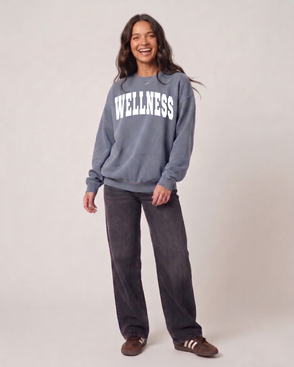 A woman wearing a blue Wellness Unisex Crew Neck Sweatshirt | Lucky Owl with white lettering, styled casually for a comfortable, wellness-inspired look.