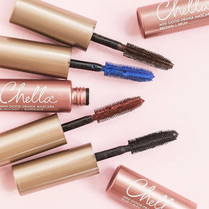 Four open tubes of Drama & Shade Mini Mascara Set | Chella laid on a pink background, showcasing mascara wands in black, blue, brown, and burgundy shades.