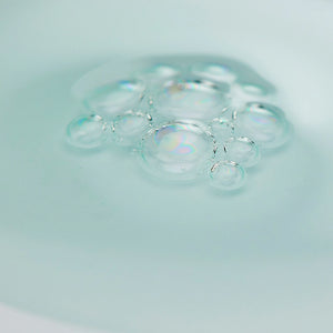 Close-up of clear, delicate serum bubbles on a smooth surface representing the moisturizing texture of Oligoforce Advanced Wrinkle & Dark Spot Correction Moisturizing Serum with Oligomer | Phytomer, highlighting skincare and hydration.