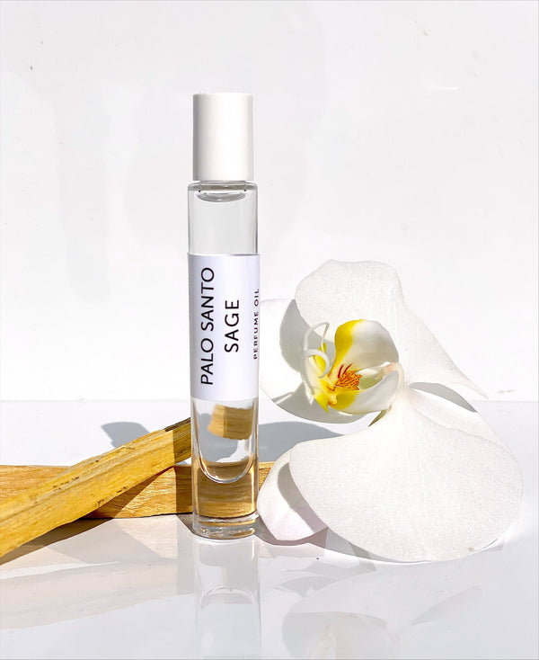 Palo Santo Sage Rollerball Perfume Oil - Spirit | Hydra Bloom displayed with natural wood and a white orchid flower, evoking a sense of wellness and skincare luxury.