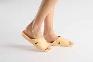 Person wearing Bonsai Slides Tan | Feelgoodz, showing lightweight and comfortable tan-colored slide sandals on a clean white background.