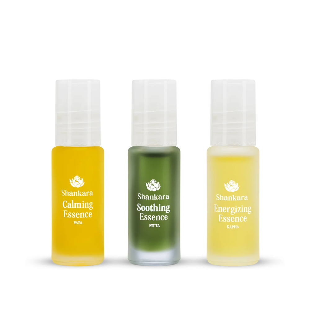 Three small frosted bottles containing yellow, green, and light yellow essences labeled Calming Essence, Soothing Essence, and Energizing Essence from Aromatherapy Collection | Shankara for skincare and wellness.