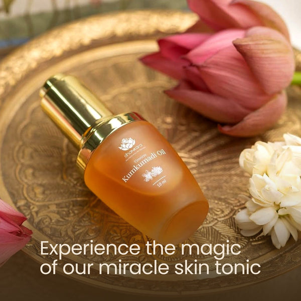 Bottle of Timeless Kumkumadi Oil | Shankara on an ornate golden tray surrounded by pink and white flowers, promoting natural skincare and wellness.