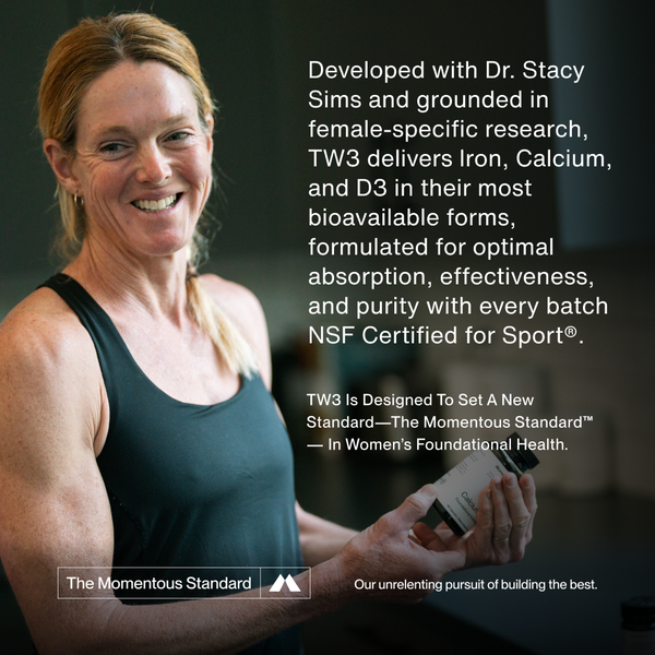 Smiling woman holding a bottle of The Women’s Three™ wellness supplement, promoting female-specific research-based formula with Iron, Calcium, and D3 for absorption and effectiveness.
