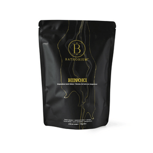 Black resealable pouch of Hinoki Cypress Magnesium Bath Flakes | Bathorium with gold and white text and wood grain design, promoting skincare and wellness.