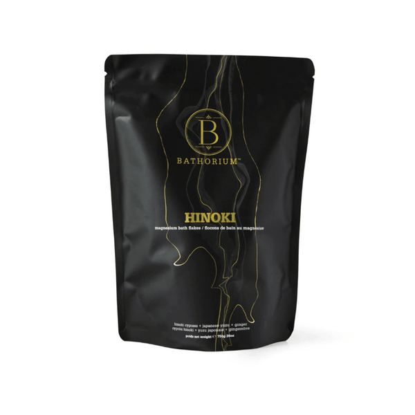 Black resealable pouch of Hinoki Cypress Magnesium Bath Flakes | Bathorium with gold and white text and wood grain design, promoting skincare and wellness.