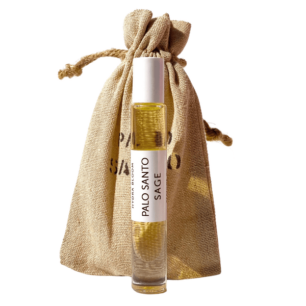 Clear glass rollerball bottle of Palo Santo Sage Rollerball Perfume Oil - Spirit | Hydra Bloom with natural beige drawstring pouch, showcasing a wellness skincare product.
