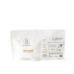 Two white resealable pouches of Amber Glow Clay Mineral Soak | Bathorium with subtle gold accents and branding, designed for skincare and body care wellness.