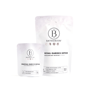 Two white resealable pouches of different sizes containing Charcoal Garden Detox Crush | Bathorium, a skincare bath soak product designed for detox and wellness.