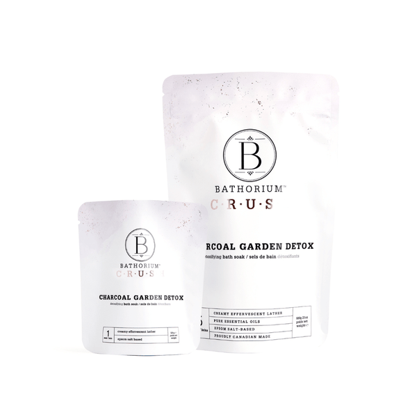 Two white resealable pouches of different sizes containing Charcoal Garden Detox Crush | Bathorium, a skincare bath soak product designed for detox and wellness.