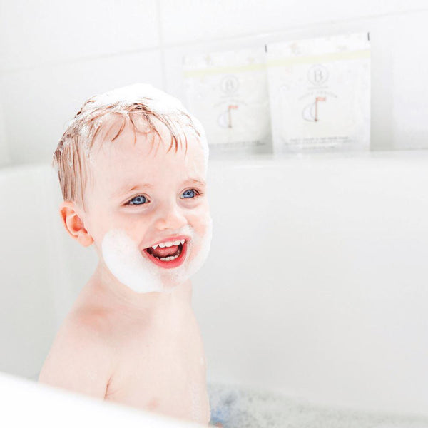 Child with bubbles on face and head enjoying a bath, showcasing the use of little charlie™ Kids Bath Soak 750g | Bathorium for gentle skincare and body care.