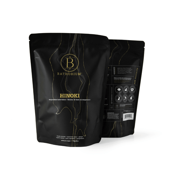 Black resealable pouches of Hinoki Cypress Magnesium Bath Flakes | Bathorium with gold and white text, highlighting wellness and skincare benefits for a spa-like experience.
