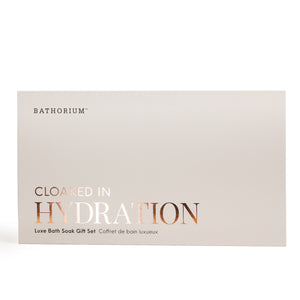 Minimalist beige gift box with elegant copper foil lettering reading Cloaked In Hydration, featuring the Cloaked In Hydration Gift Box Set | Bathorium for skincare and body care wellness.