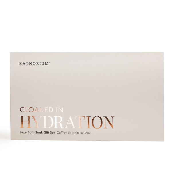 Minimalist beige gift box with elegant copper foil lettering reading Cloaked In Hydration, featuring the Cloaked In Hydration Gift Box Set | Bathorium for skincare and body care wellness.