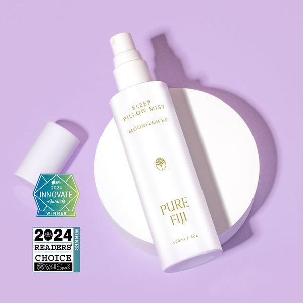 White spray bottle of Pillow Mist | Pure Fiji with awards displayed on a lavender background, suggesting a calming and luxurious wellness product for skincare and sleep care.