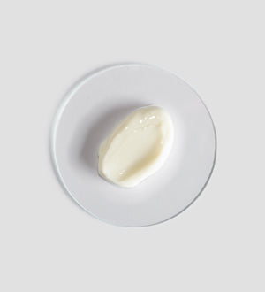 Close-up of a smooth, creamy white skincare product texture displayed on a clear round surface, representing Renight Cream | [ comfort zone ] for body care and wellness.