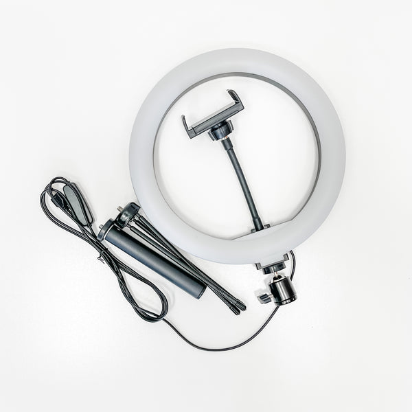 Compact Ring Light - 10" with adjustable tripod stand, flexible phone holder, and USB power cable for enhanced lighting in skincare and wellness device setups.