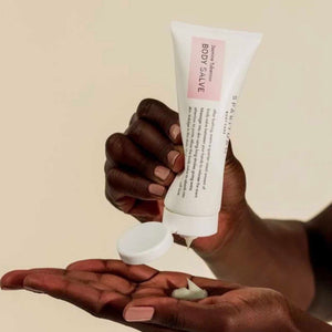 Person dispensing creamy Jasmine Tuberose BODY SALVE | Sparitual from a white tube onto their hand, highlighting skincare and body care routine.