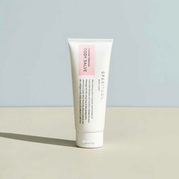 Tube of Jasmine Tuberose BODY SALVE | Sparitual standing on a flat surface with soft natural lighting, showcasing minimalist packaging for skincare and body care.