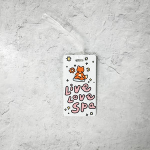 Luggage Tag - Meditating Fox- Limited Edition | Lucky Owl featuring a cute orange fox meditating above the words "Live Love Spa" with stars and celestial designs on a white background.