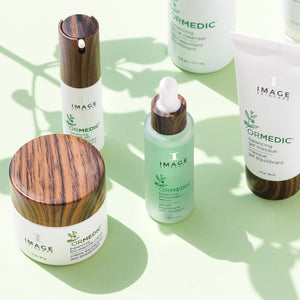ORMEDIC balancing eye lift gel | IMAGE Skincare featured among other skincare products with natural wood-textured caps on a light green background, emphasizing wellness and body care.