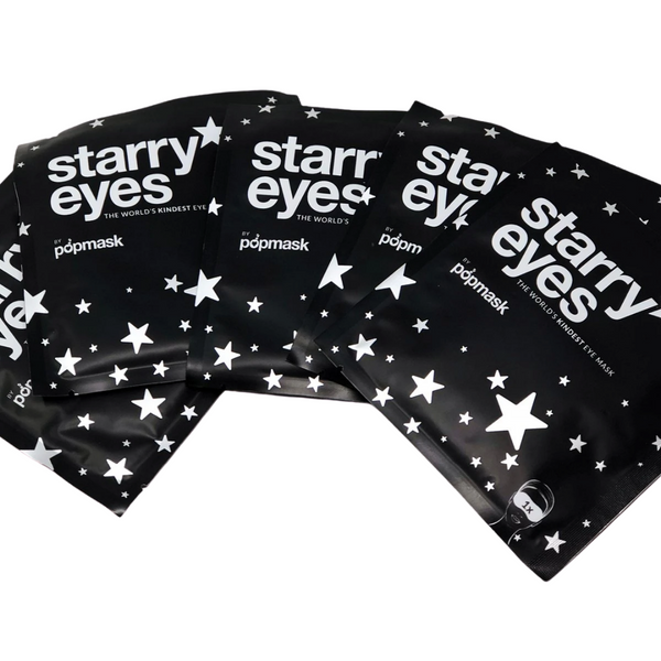 Four black foil packets of Starry Eyes Warming Eye Mask - Single | Popmask featuring white star designs and bold white text, promoting skincare and wellness.