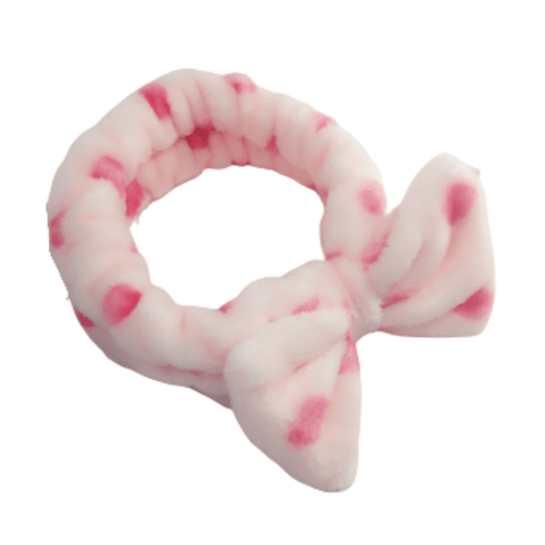 Soft pink and white polka dot fabric Spa Headbands | Live Love Spa with a bow detail, designed for skincare and wellness routines.