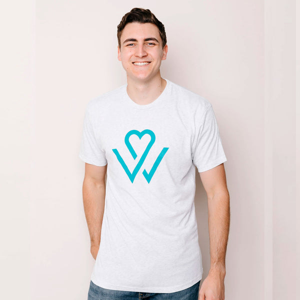 Young man smiling and wearing a white Wellness Month Logo – Unisex Shirt | Wellness Month featuring a teal heart and checkmark design, promoting wellness and self-care.