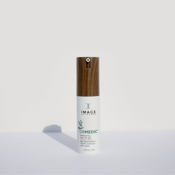 ORMEDIC balancing eye lift gel | IMAGE Skincare in a sleek white bottle with a wood-textured pump, designed for gentle skincare and eye area rejuvenation.